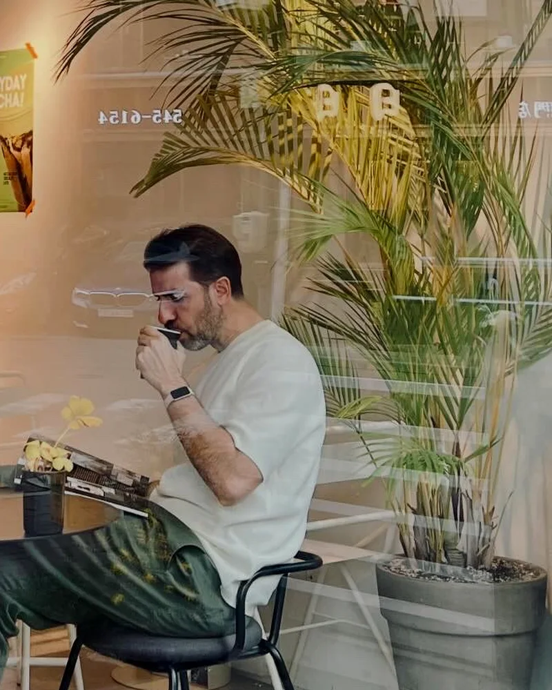 Adrià reading with a coffee on a trip