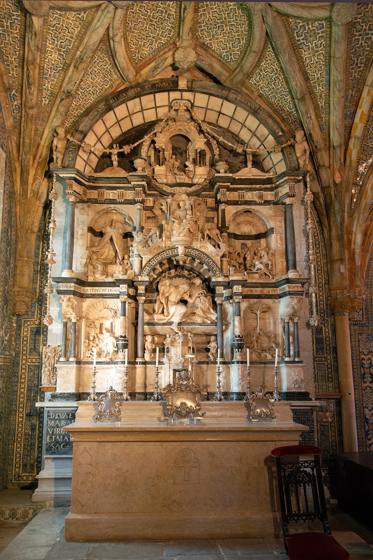 Marble and alabaster altarpiece in the chapel of Pena Palace, carved scenes in niches under a tiled vaulted ceiling