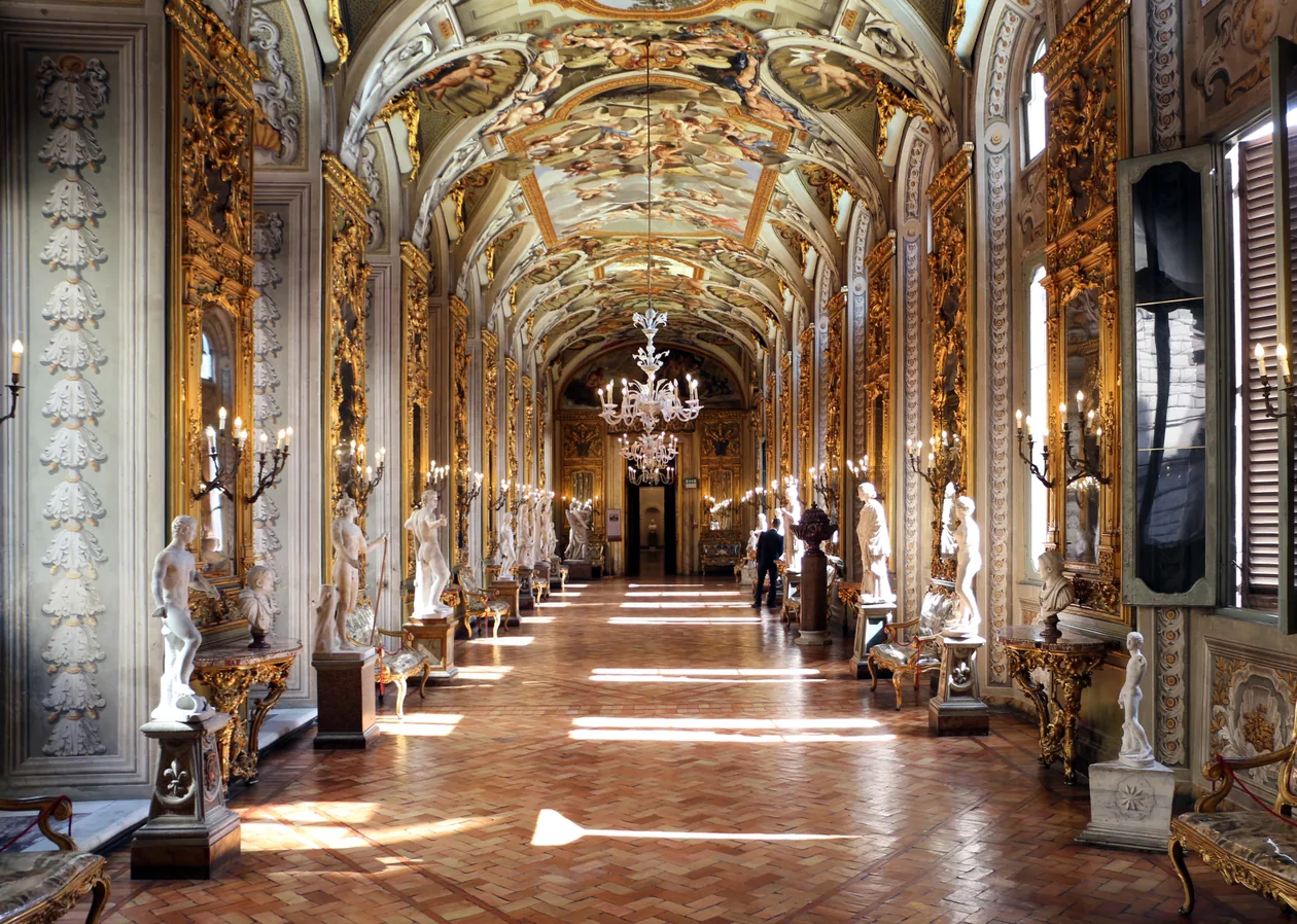 The Hall of Mirrors at the Doria Pamphilj Gallery, Rome, lined with gilt frames and antique statues