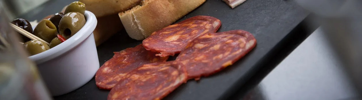Cured meats, olives, and bread on a board in Florence