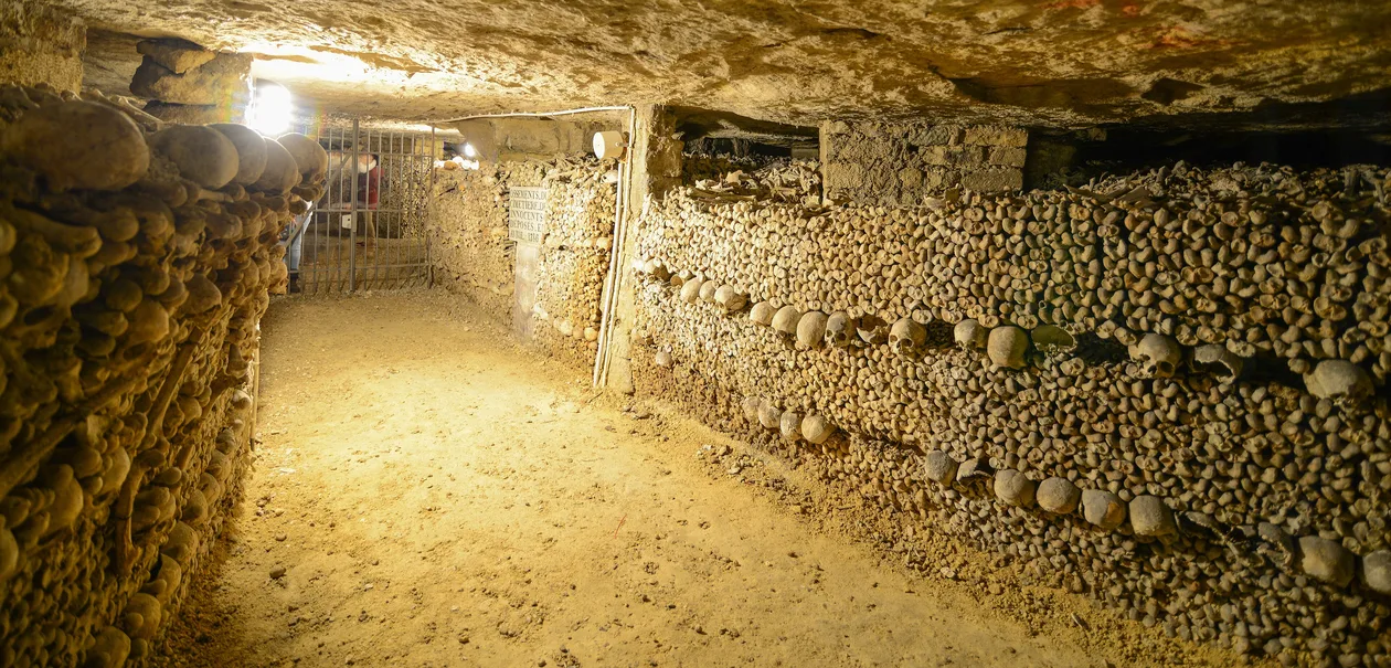 Catacombs of Paris — skull and femur walls lit by the 2026 theatrical LED lighting