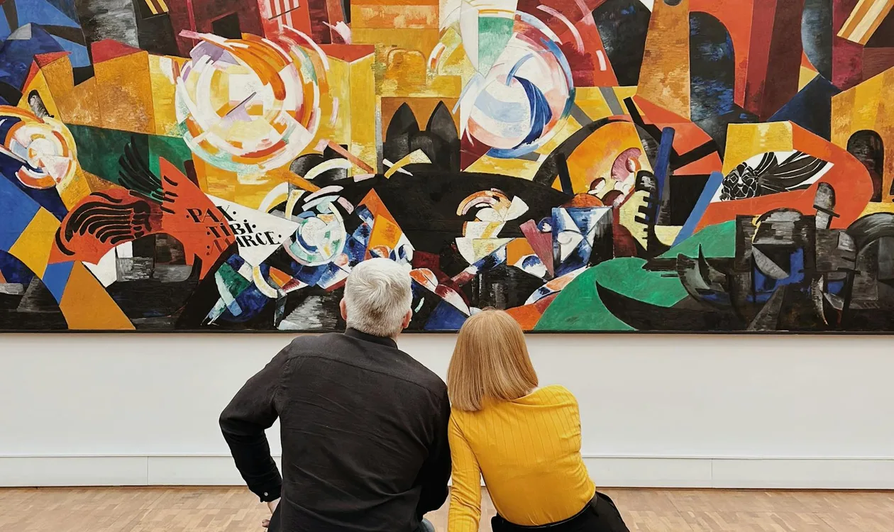 Visitors sitting in front of a large colourful painting in a modern art gallery