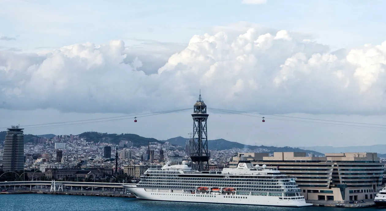 Cruise ship docked by the World Trade Center in the Port of Barcelona, with the Torre Jaume I cable-car tower and the city behind